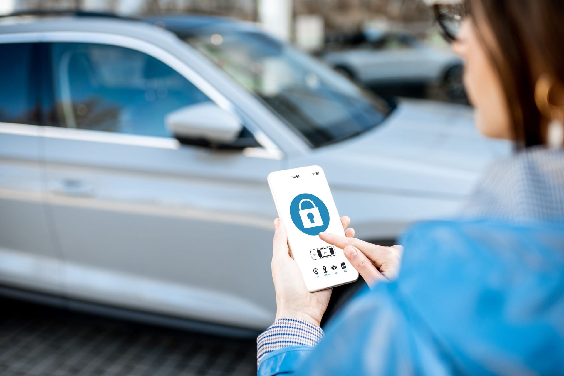 スマートフォンで車を解錠する女性